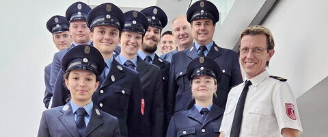 Feuerwehrkamerad:innen und -kameraden nach bestandener Prüfung auf der Treppe im Feuerwehrhaus